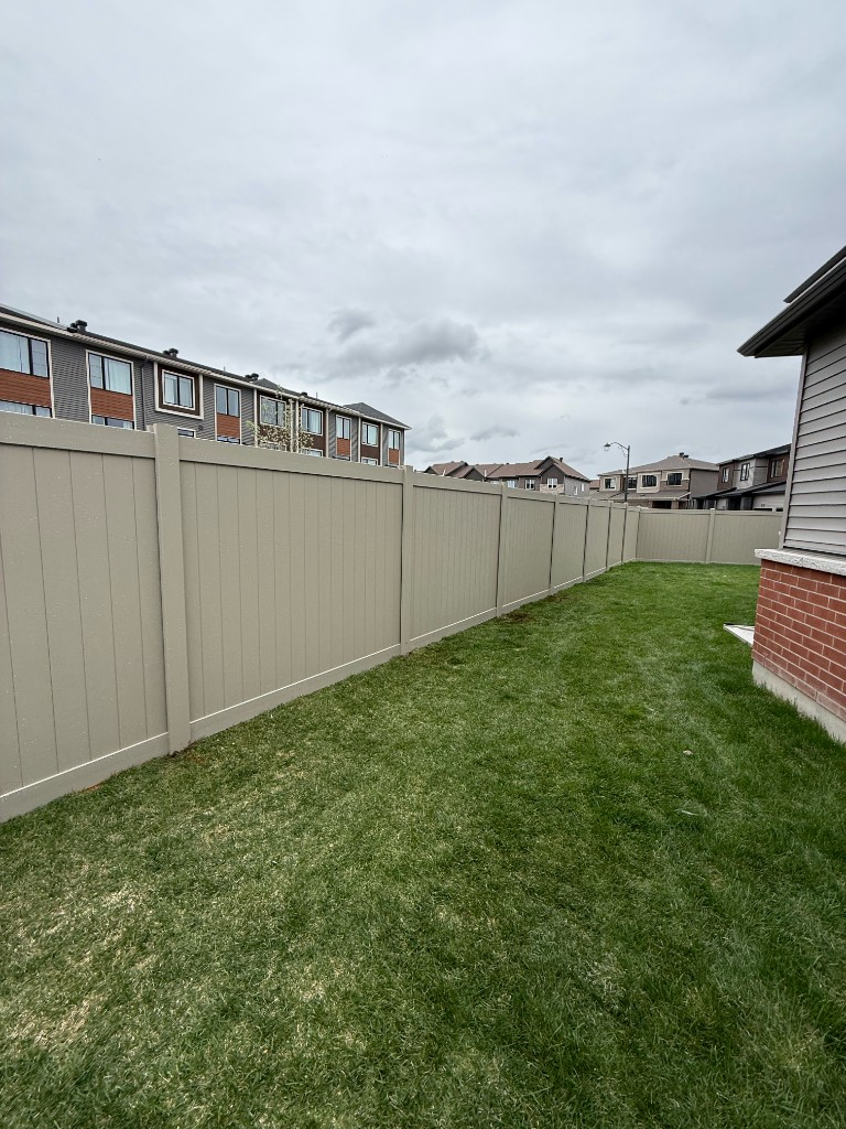 Tan vinyl privacy fence installation in an Ottawa backyard