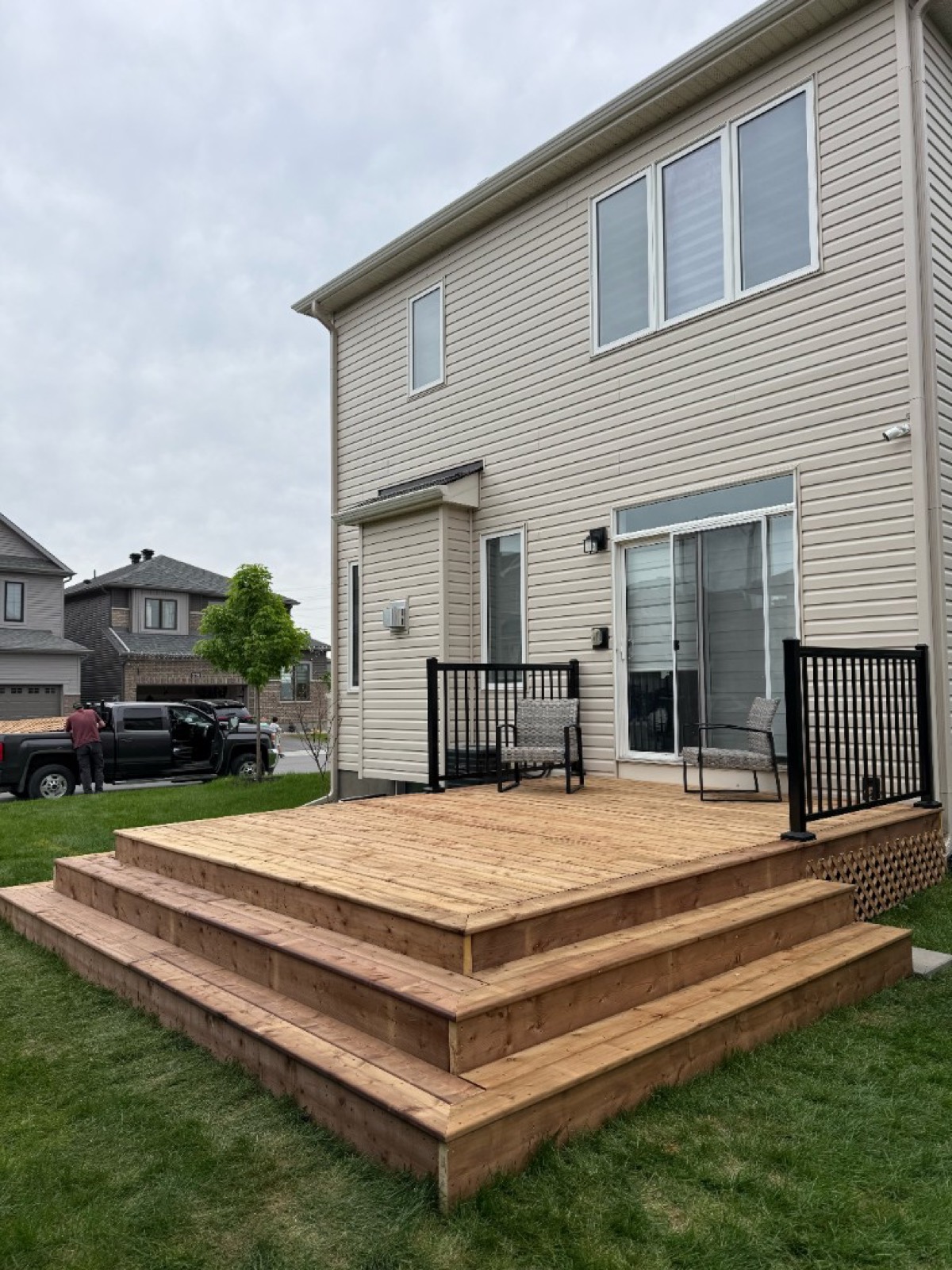 Custom backyard wood deck with black aluminum railing in Ottawa - Gordon Landscaping